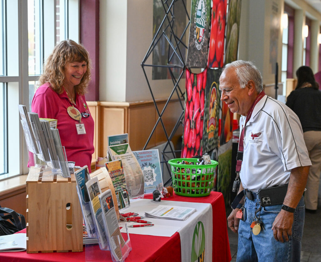 Associate Dean Dr. E.N. Escobar talks to a vendor at the 21st Small Farms Conference.
