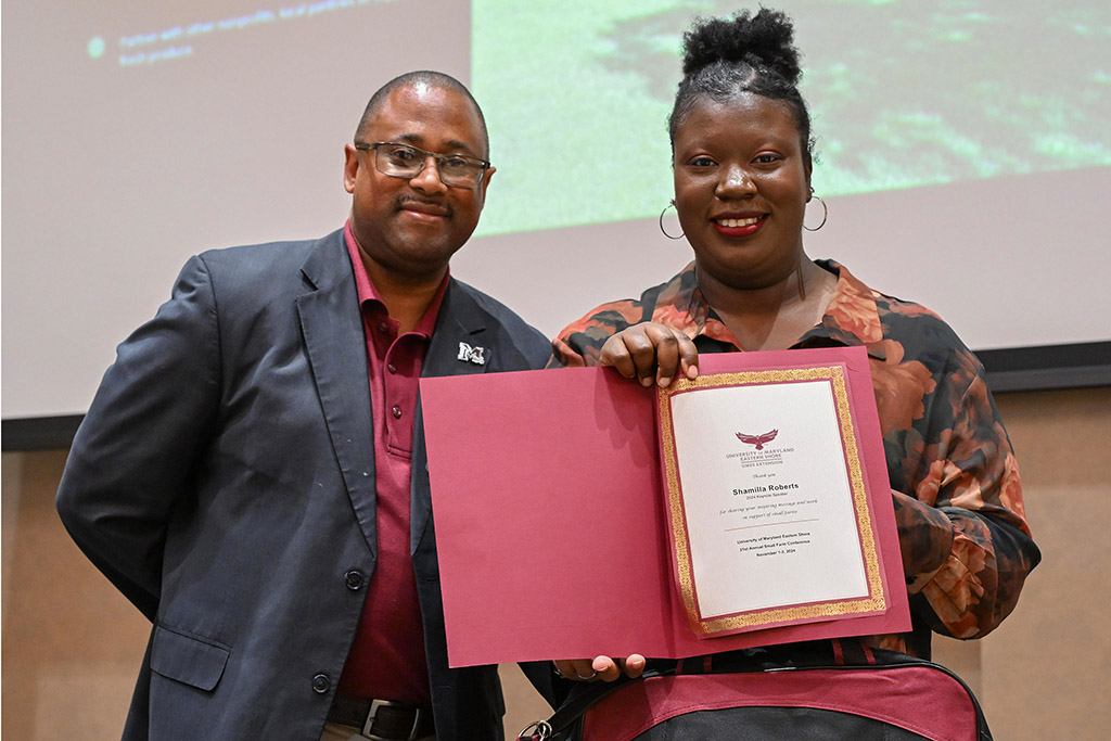 Small Farm Coordinator Berran Rogers presents a certificate to keynote speaker Shamilla Roberts at 21st Small Farm Conference.