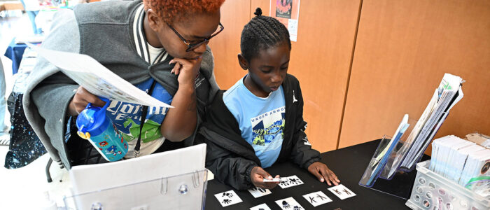 Tiffany Burgess, Aunt of Jacoby Townsend of Princess Anne watch him match footprints of animals during the 2025 UMES 4-H STEM Expo.