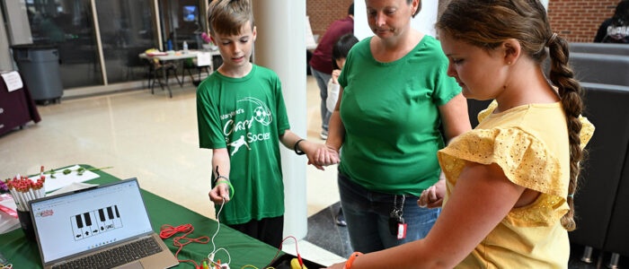 From left, Maxwell Turley, 11, Jodie Turley and Layla Bullism, 10, complete a circuit to play the fruit panio during the 2025 UMES 4-H STEM Expo.