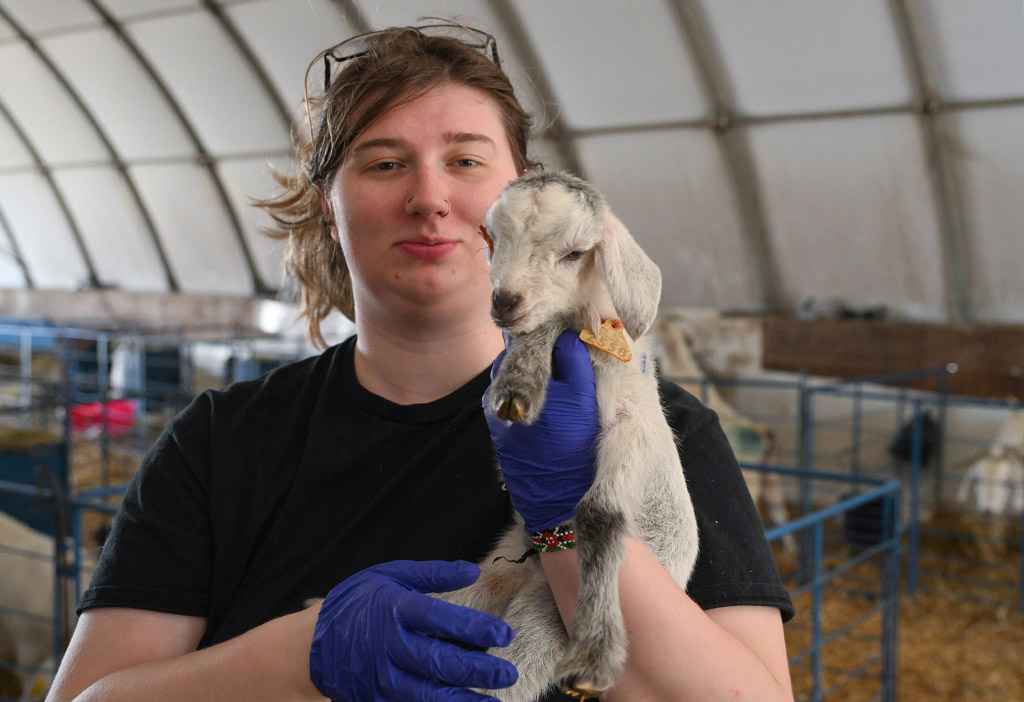 Olivia Ludolph holds a baby goat.