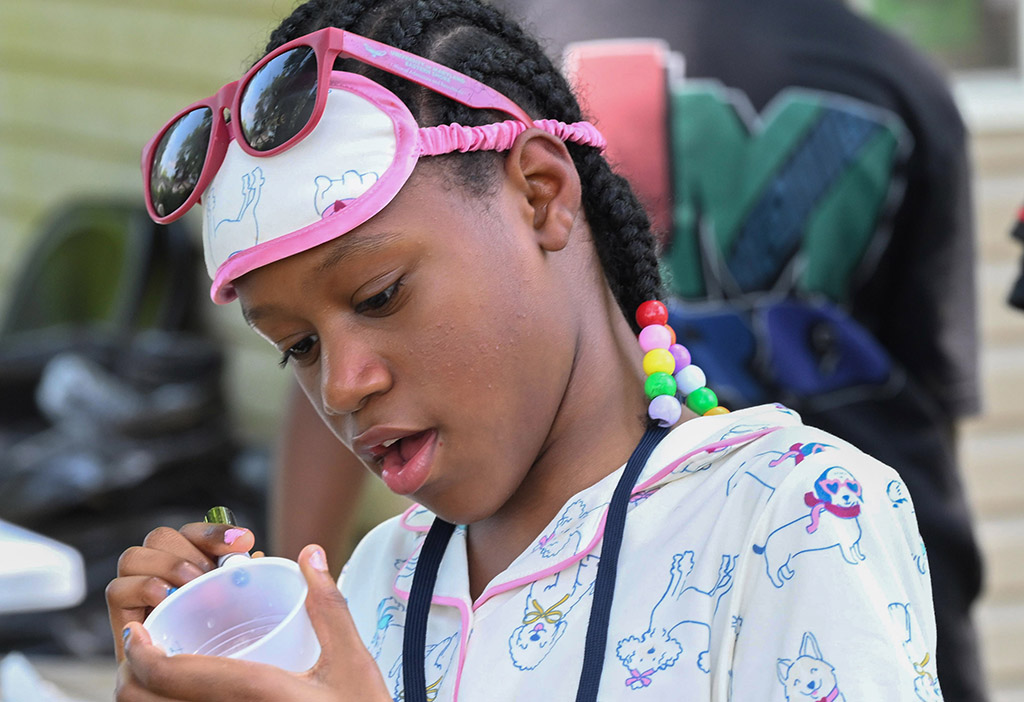 Camp SLAM student Kayla Viillarson draws on a cup.