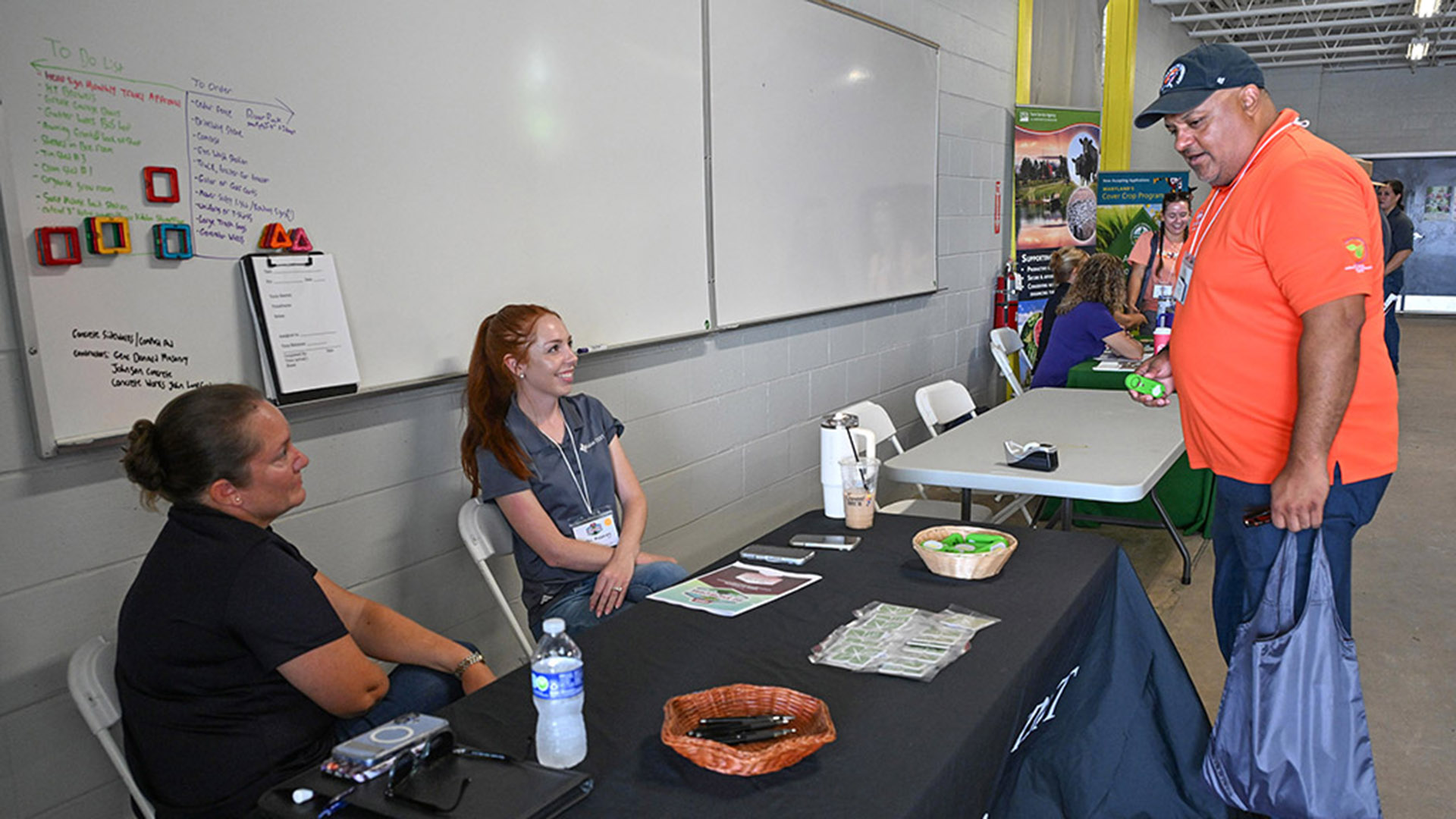 TGD-agshowcase-1785 Ag Showcase attendee checks out an exhibitor table.