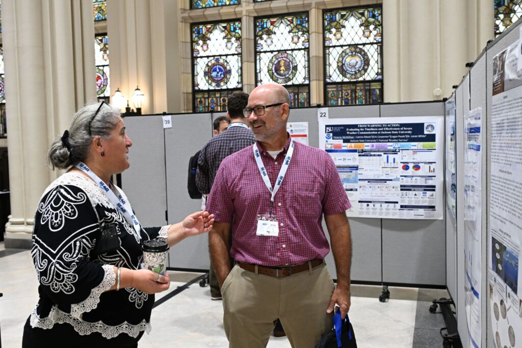 Drs. Gulnihal Ozbay (left) and Joe Pitula review posters at the 2026 NOAA EPP forum.
