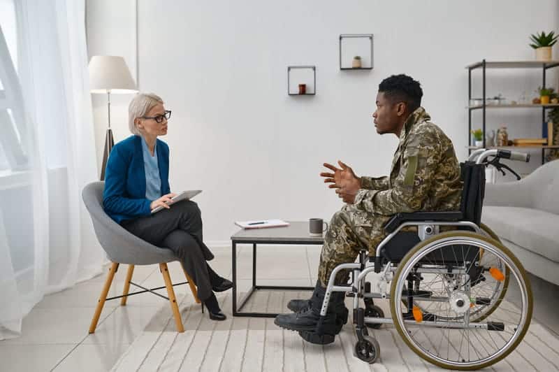 B.S. in Rehabilitation Psychology—counselor meeting with a wheelchair user in a supportive conversation.