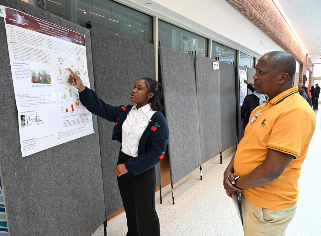 Student talks about her poster at Student-led Undergraduate Research Symposium in 2024.