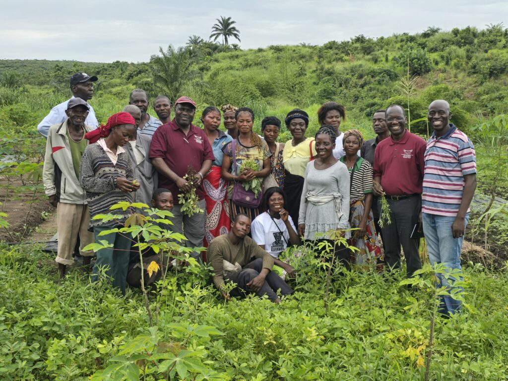Posing for a photo are farmers trained on seedlings reproduction, plant and animal pests, and diseases management, water management, postharvest and food processing at the UNIKIN experimental station
