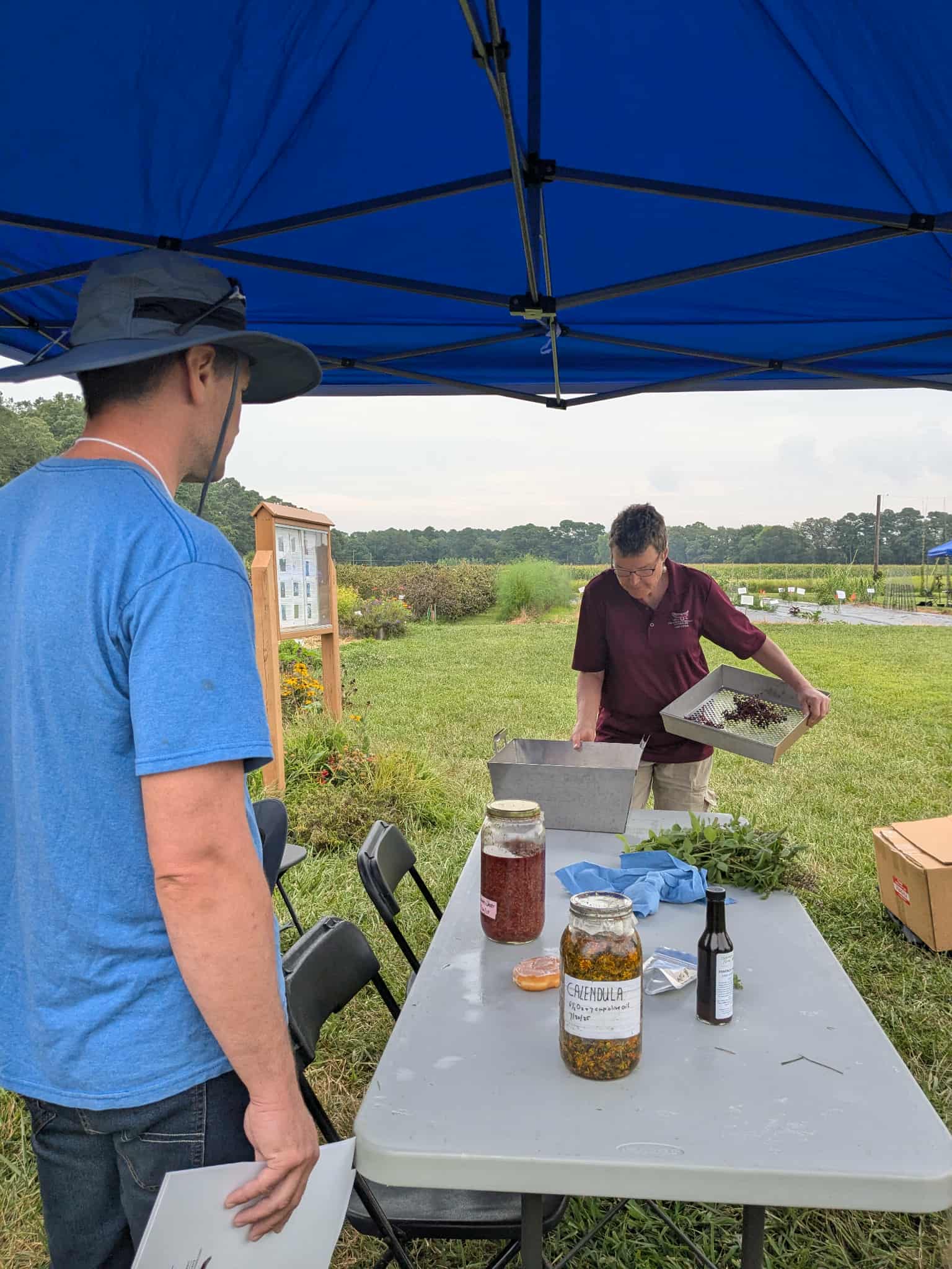 A workshop participant watches a UMES Extension specialty herbalist demonstrate herb harvesting.
