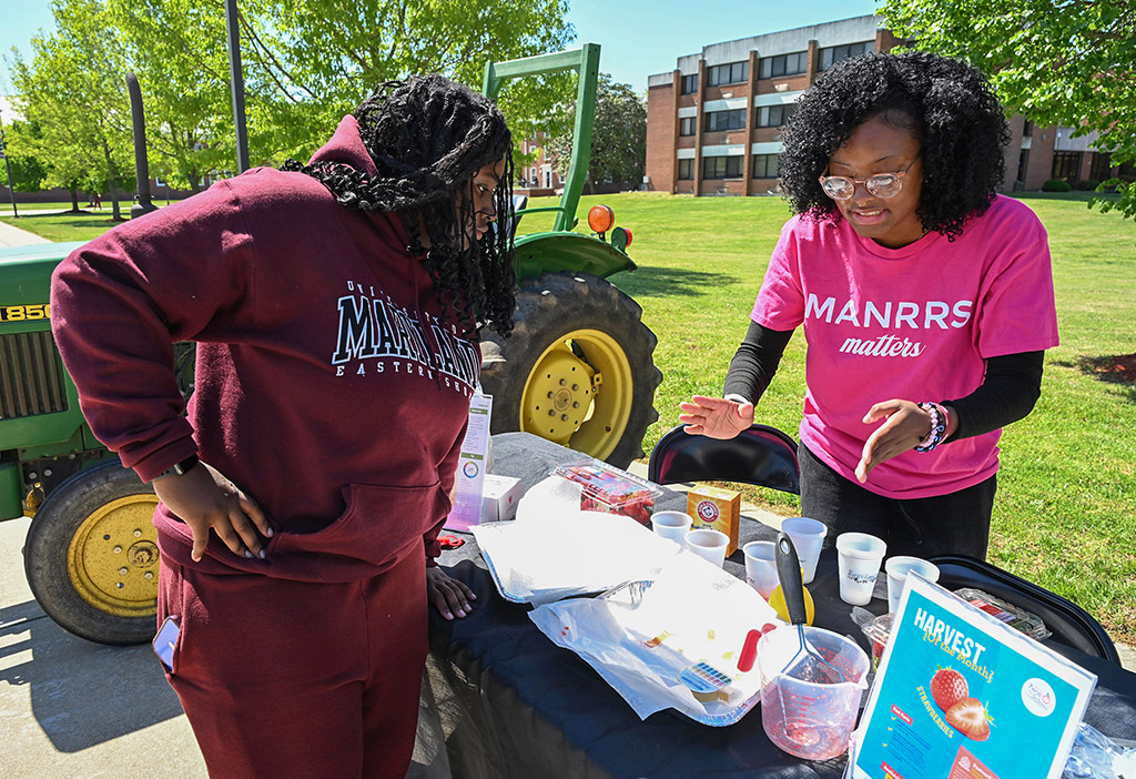 Daijah Cabean, a junior at UMES, learns from MANRRS member Amari Christopher about how pH test for strawberries at the annual DASL Expo.