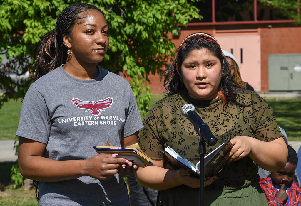 ESA Club members Alleyah Britton, left, and Mel Montoya read passages about the importance of trees during the UMES Earth Day celebration.