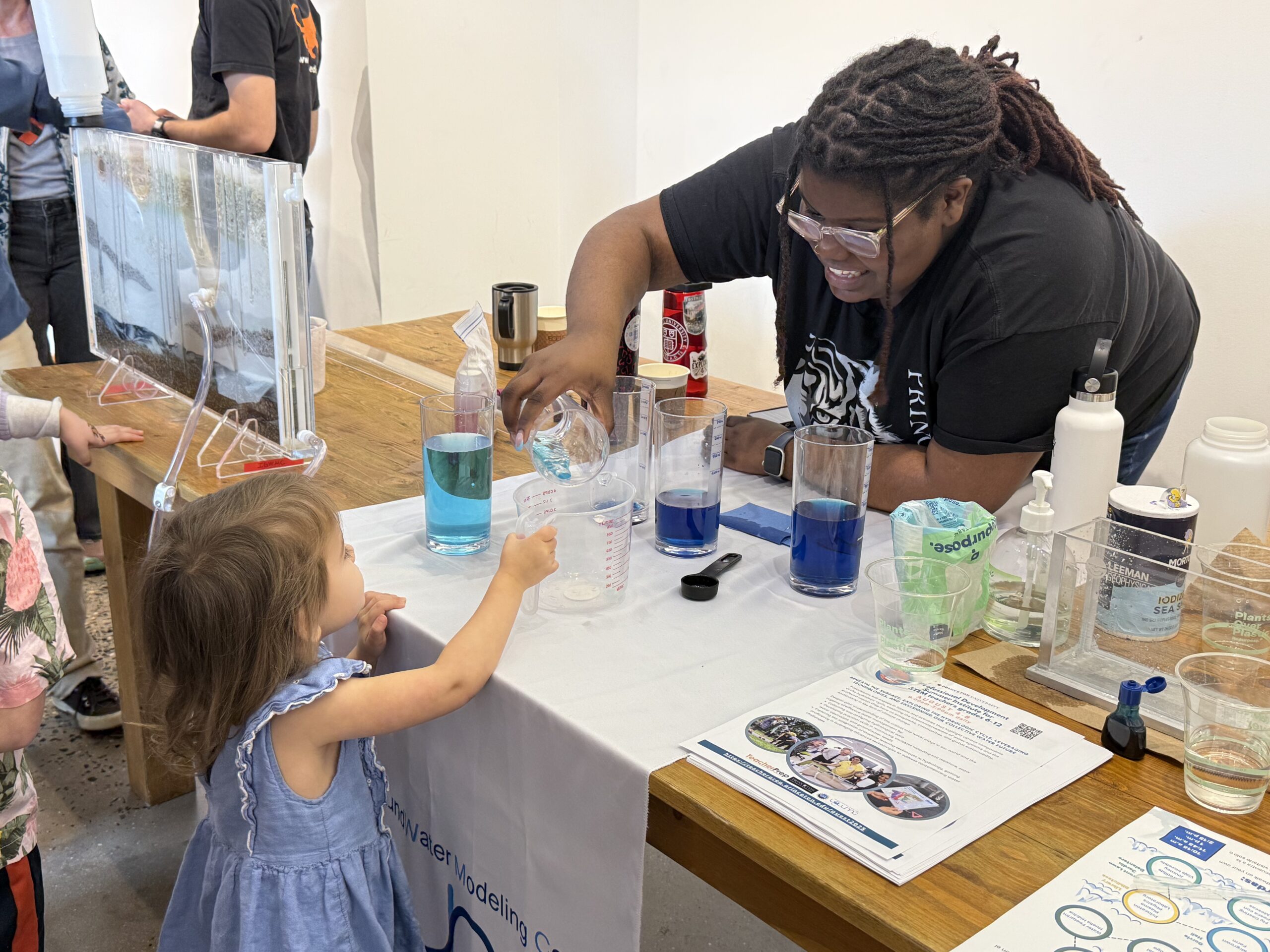 UMES alumna Jasmine Pinchinat now working at Princeton helps a child with an experiment during Princeton World Water Day education and outreach event.