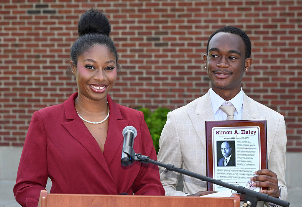 Miss UMES Brooke Chaney, left, and Mister UMES Malachi Robinson get ready to give a gift to the Haley family during the naming ceremony of the Simon A. Haley School of Agriculture & Natural Sciences.