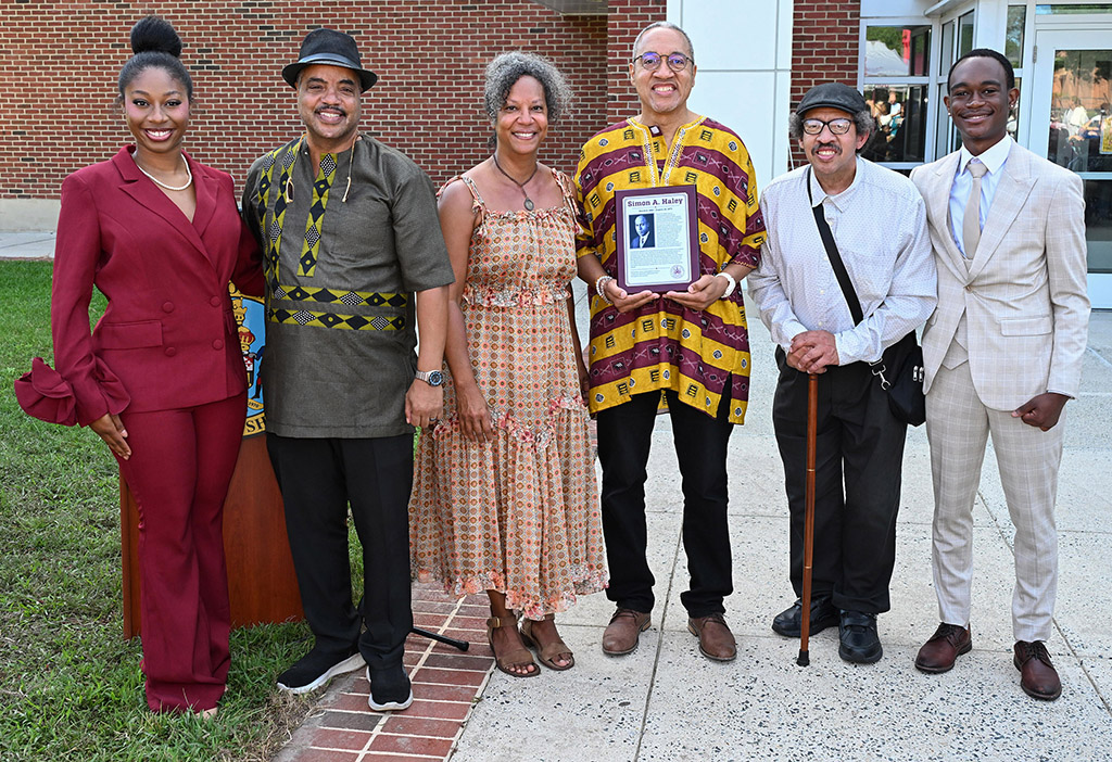 From left, Miss UMES Broke Chaney, Bill Haley, Anne Haley, Chris Haley, Alan Haley, and Mister UMES Malachi Robinson pose with the plaque during the naming ceremony of the Simon A. Haley School of Agriculture & Natural Sciences.
